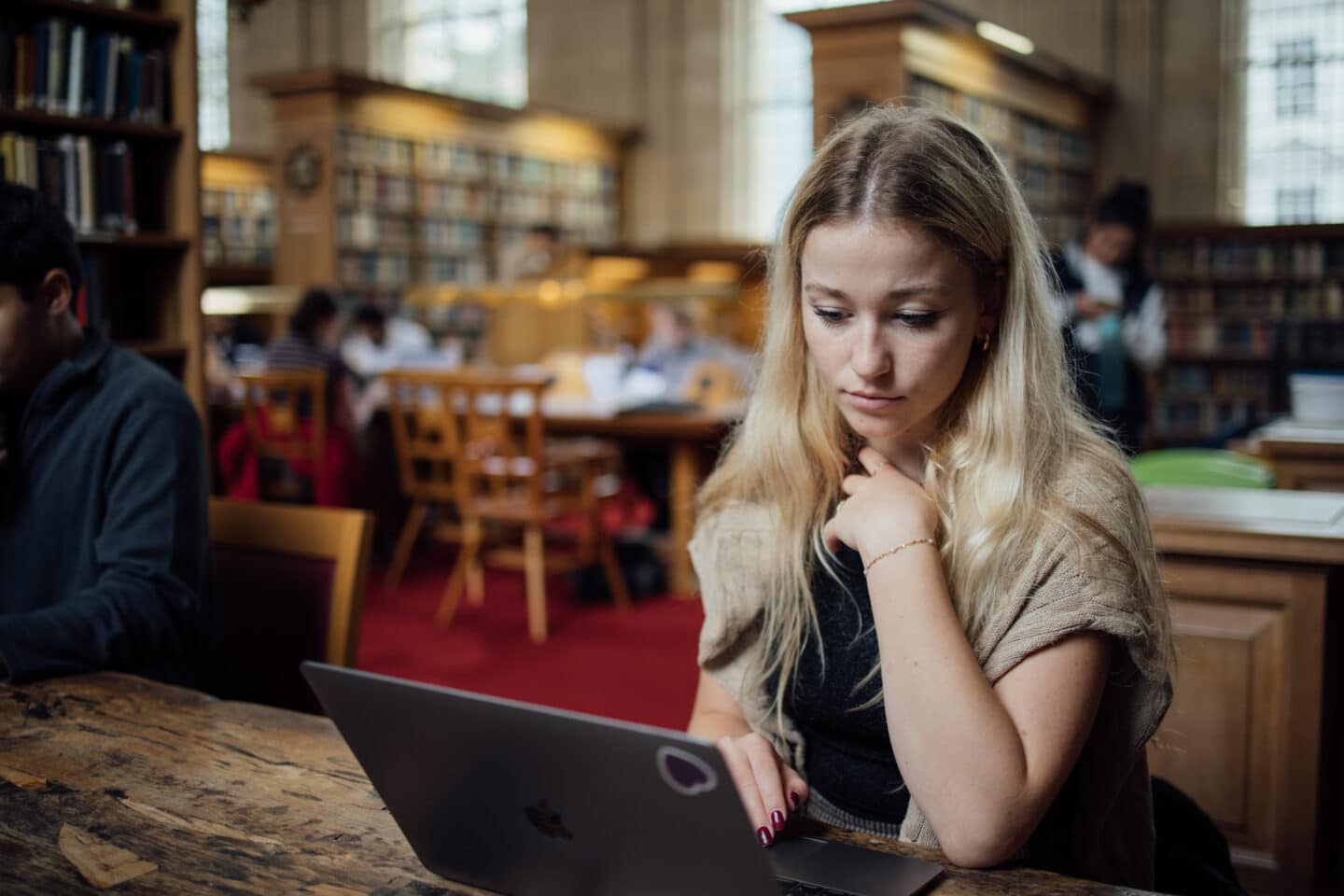 Student looking at her laptop in the Library