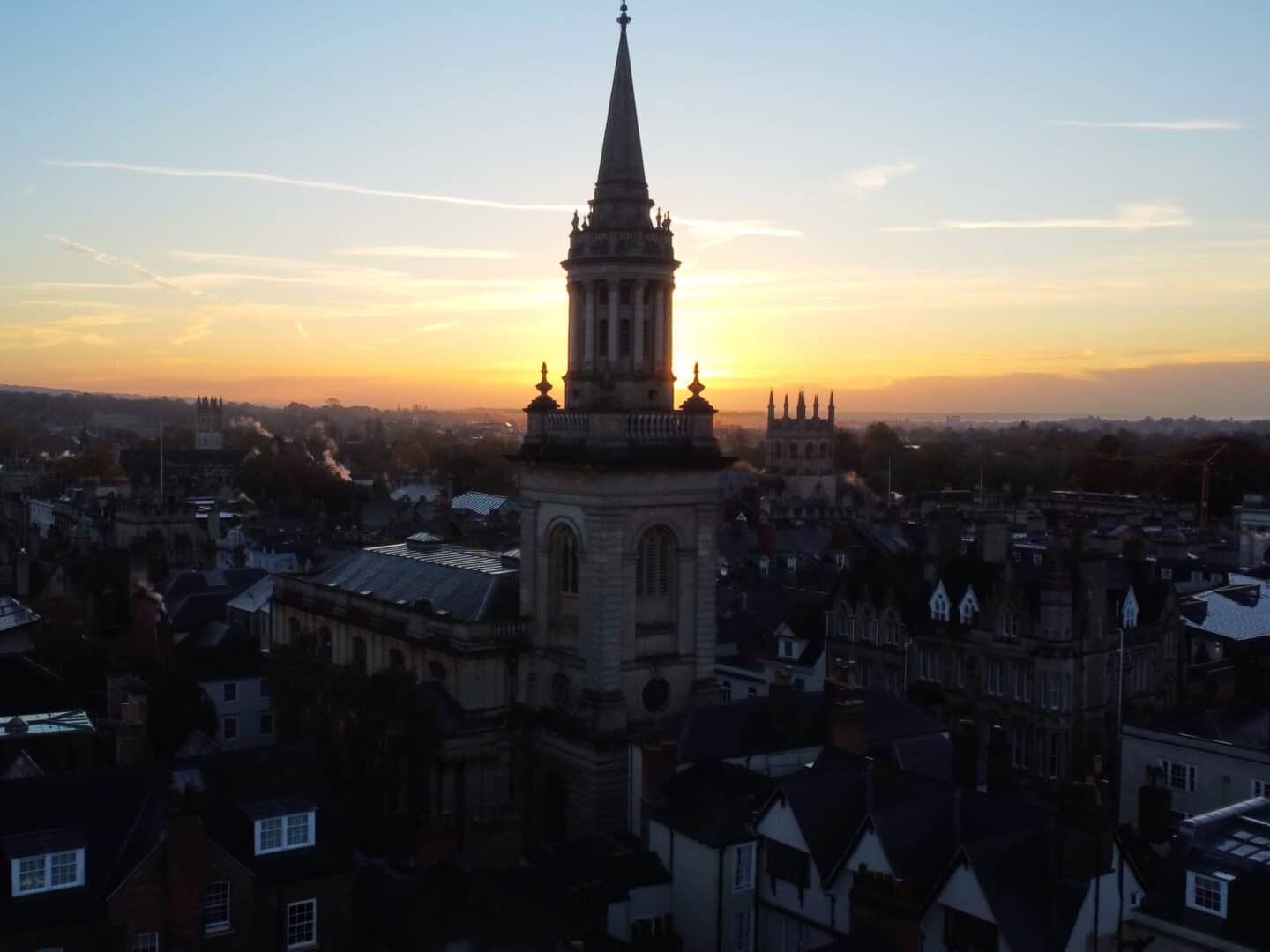The spire of the Lincoln College Library tower standing out in the Oxford skyline at sunrise/sunset