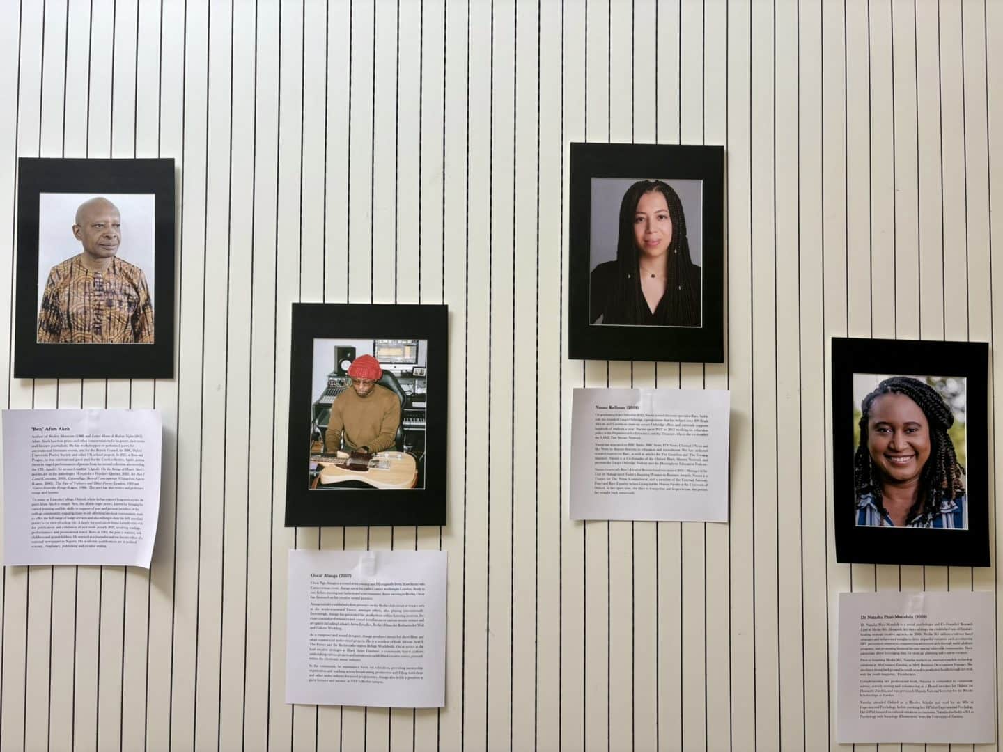 Section of the Black at Lincoln exhibition showing four framed portraits of Black Lincoln alumni and associated figures, displayed against the white-panelled wall of the Berrow Foundation Building.