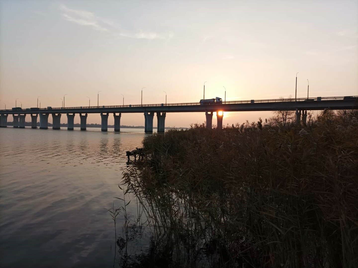 Antonivka bridge in Kherson Ukraine, over the water as the sun rises.