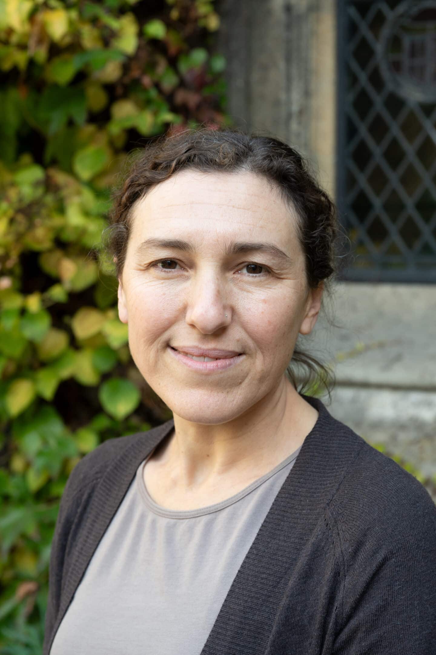 Kinneret standing in Front Quad at Lincoln College, Oxford, in front of ivy-covered stonework.