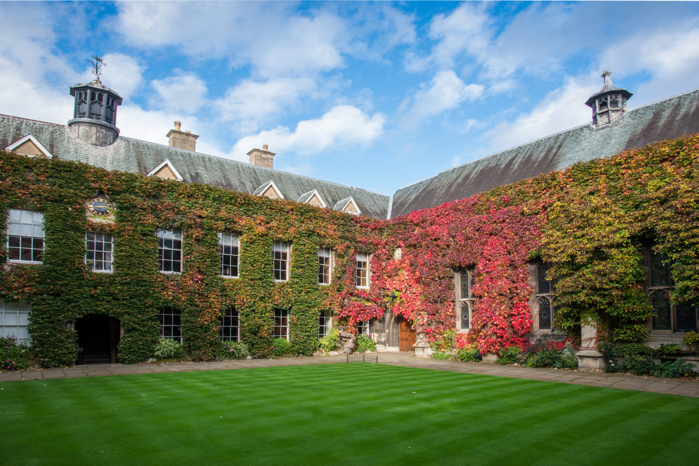 View of the Front Quad at Lincoln College, Oxford, under a clear blue autumn sky, with ivy showing shades of gold and red.