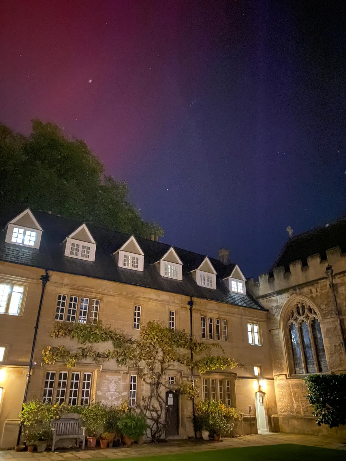 Photograph of Lincoln College's Chapel Quad, with the sky lit up in pink and purple above
