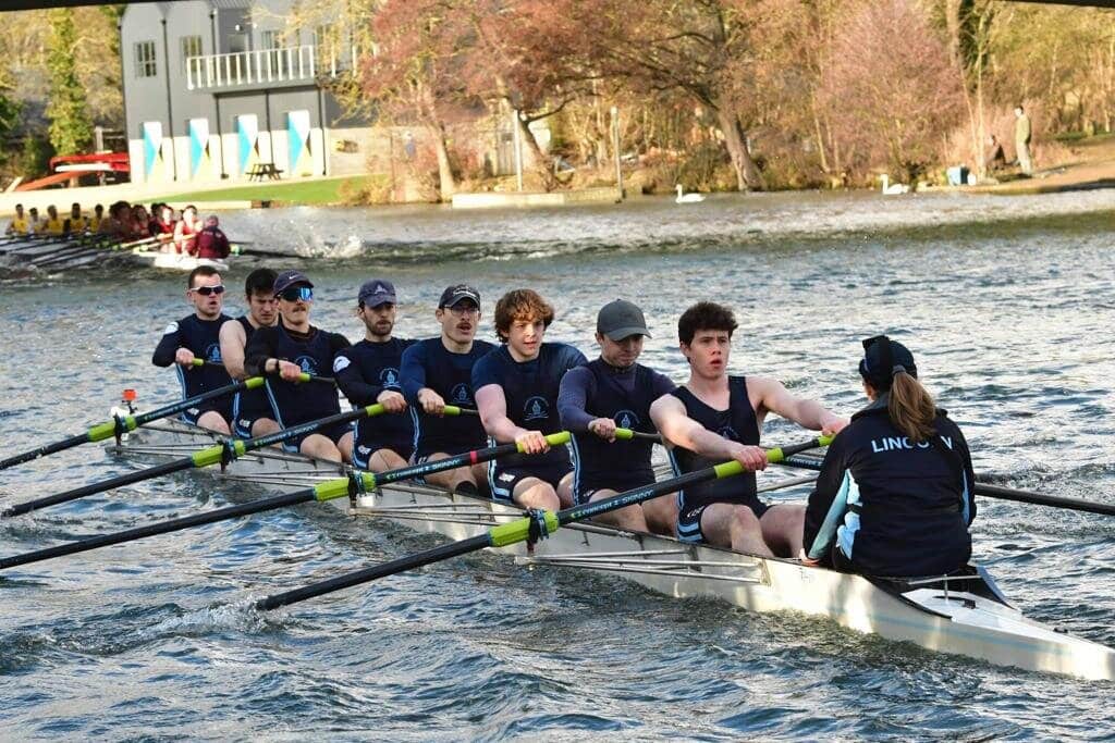 Crew of Lincoln students rowing on the river.