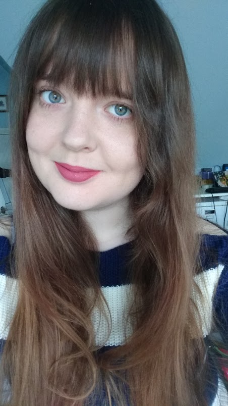 Headshot of Alice Parkin, a young woman in a blue and white striped sweater