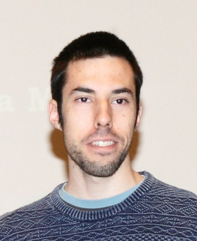 Headshot of Arnau Bertran, a young man in a blue-grey sweater