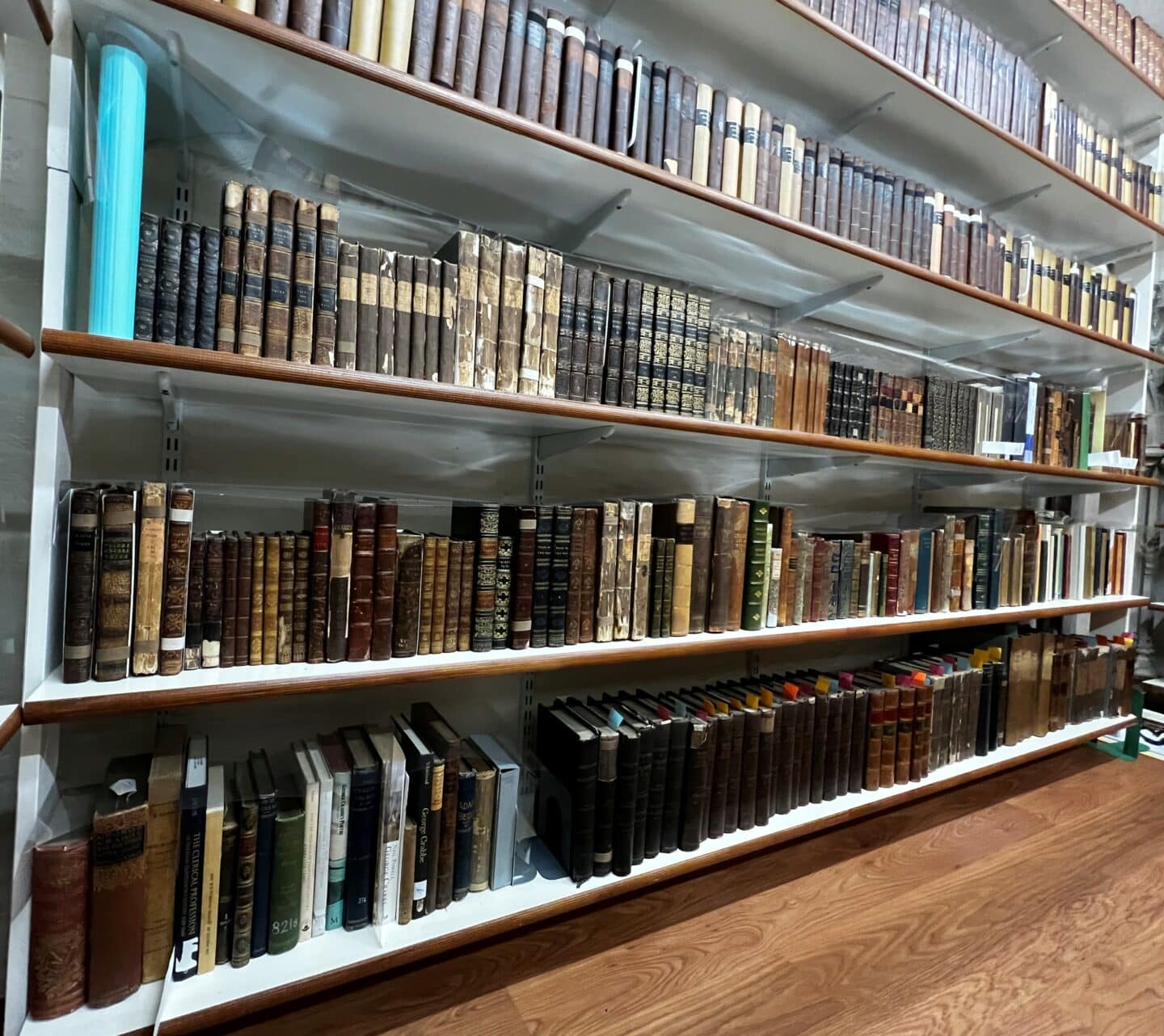 A very long high set of bookshelves, with rows of old books