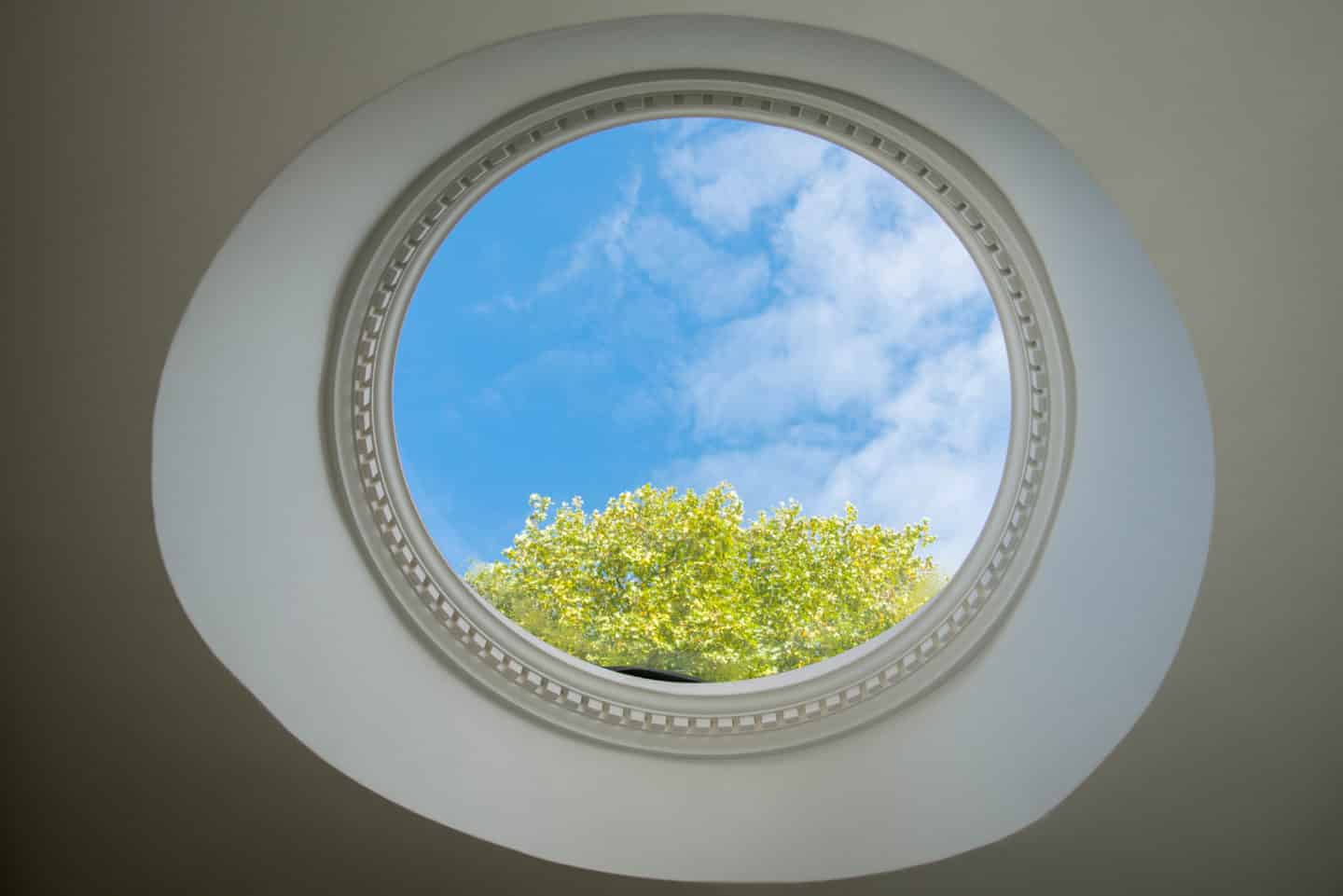 View of the blue sky through a circular window