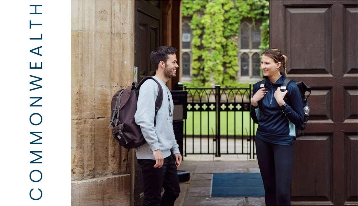 Photo of a smiling young man and woman in front of the open main gate to Lincoln College, with Commonwealth inscribed on the left.