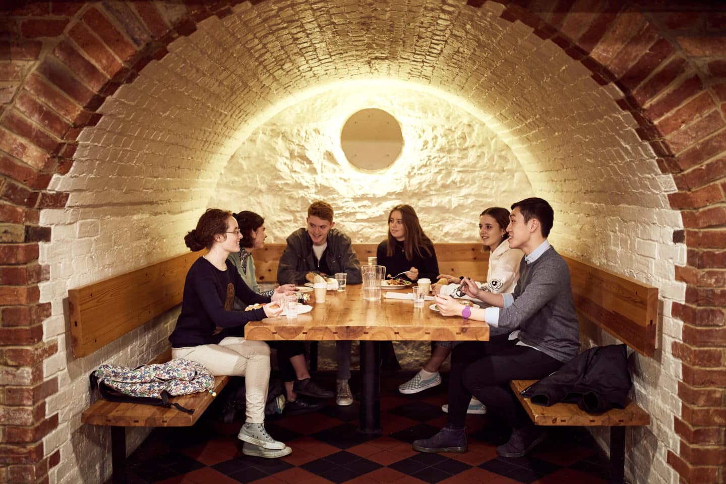 Students sitting around a table eating in the Lincoln College Bar