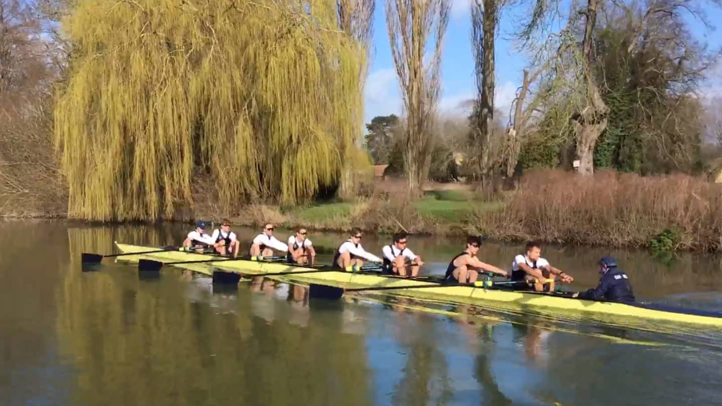 9 rowers in a boat on the river