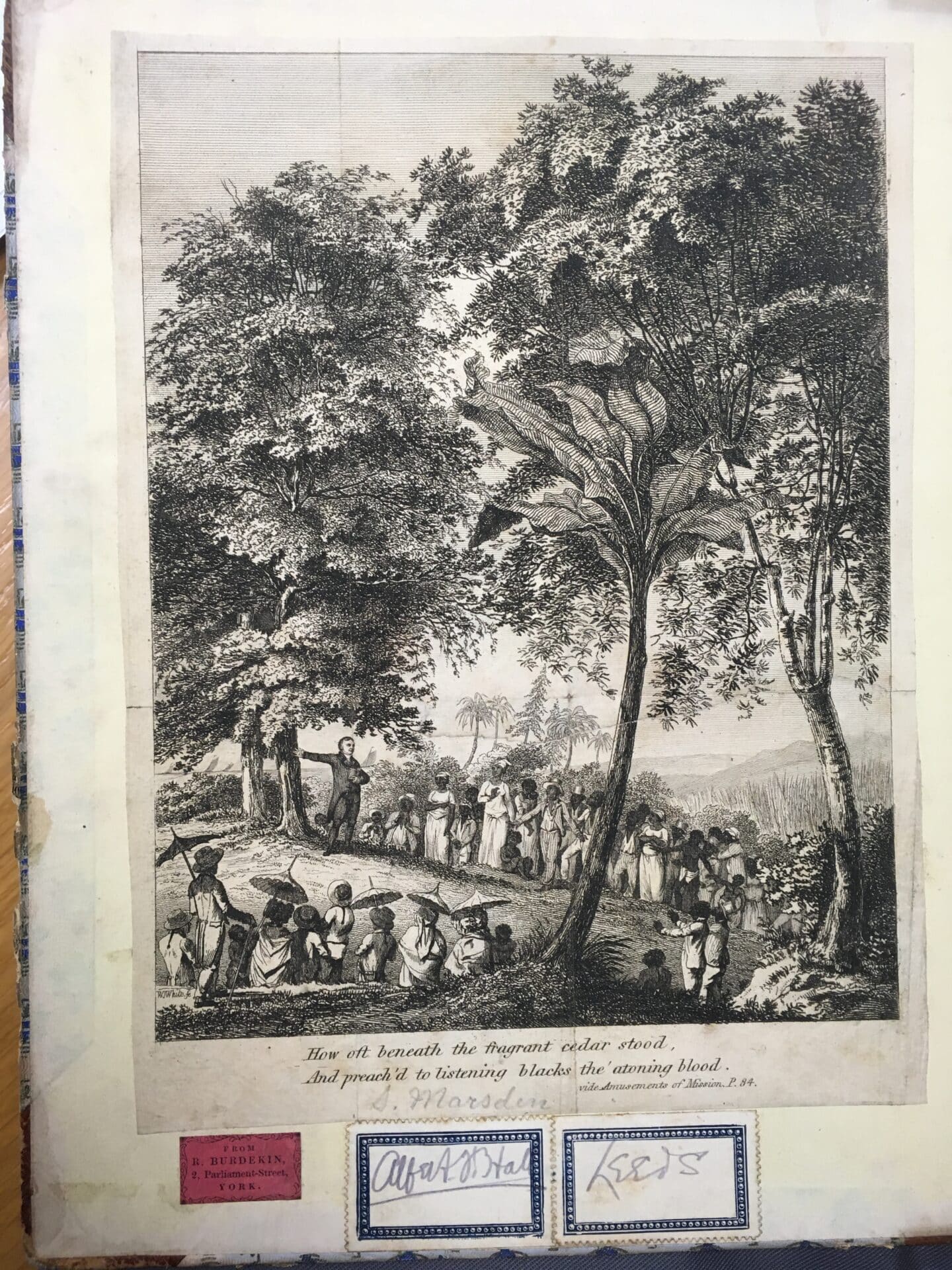 Image of a man standing and preaching below a tree to a crowd of people, with the caption: 'How oft beneath the fragrant cedar stood, And preached to listening blacks the atoning blood.'