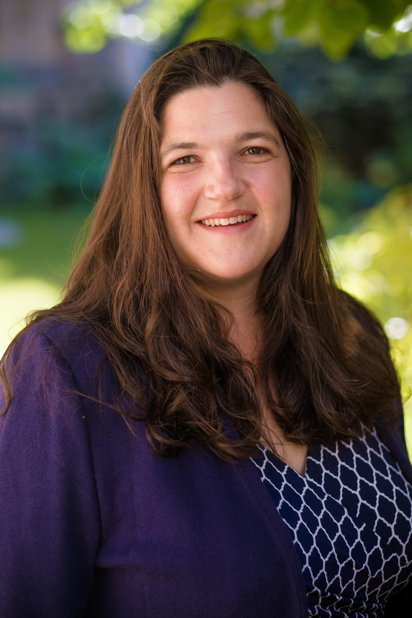 Headshot of Kimberly Palladino, a woman in a blue and white top and purple jacket