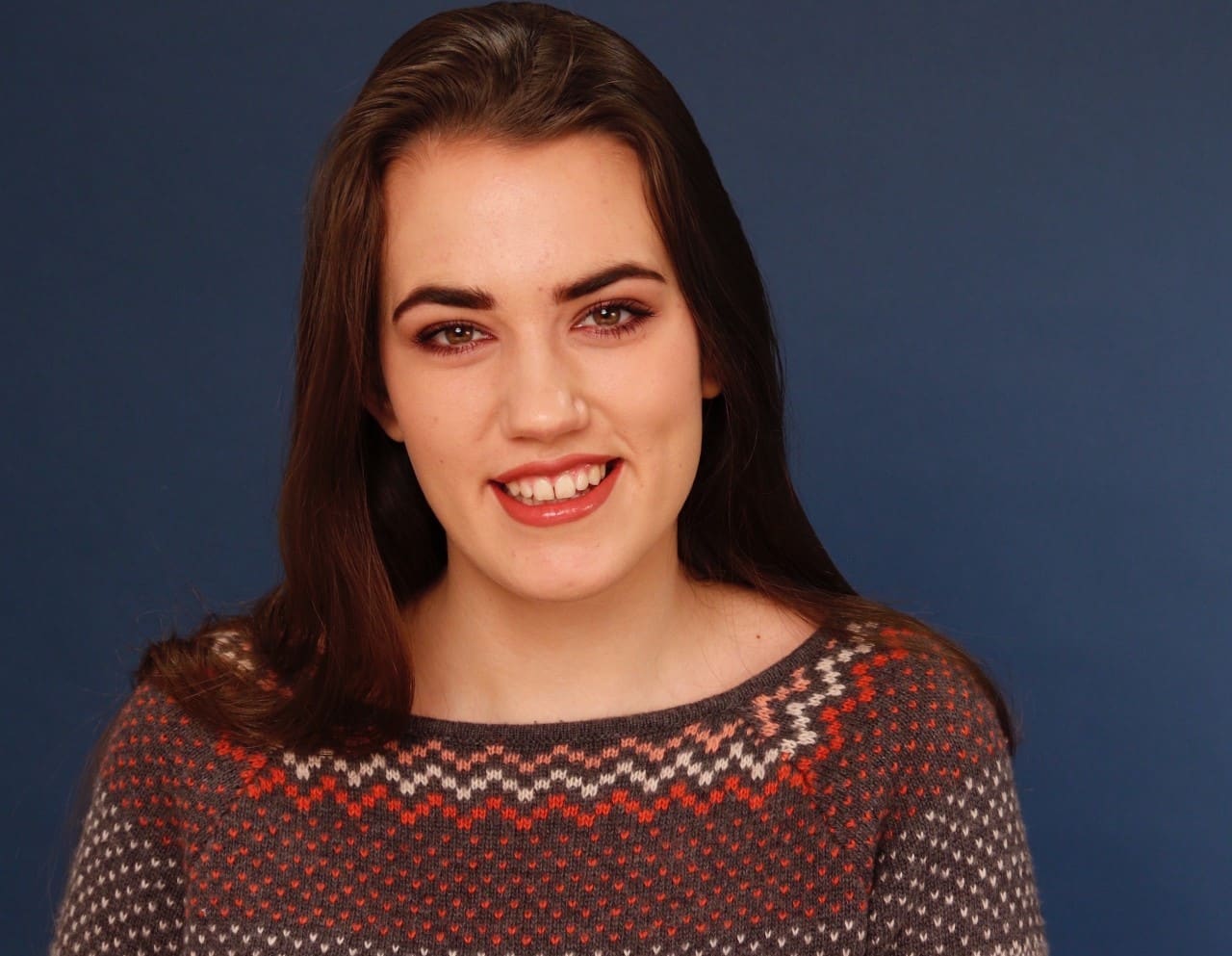 Headshot of Lana Gotvan, a young woman wearing a brown and red sweater