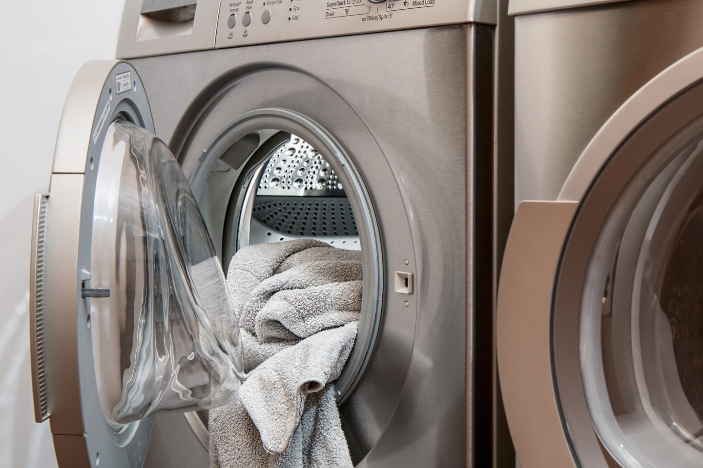 Image of towels spilling out of an open washing machine/drier