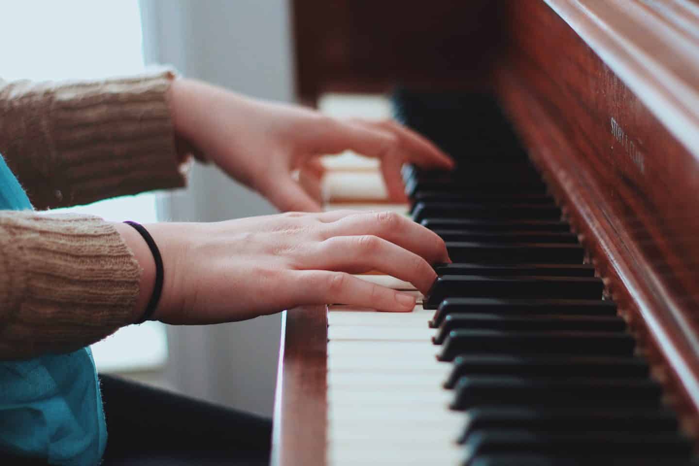 Hands playing a piano