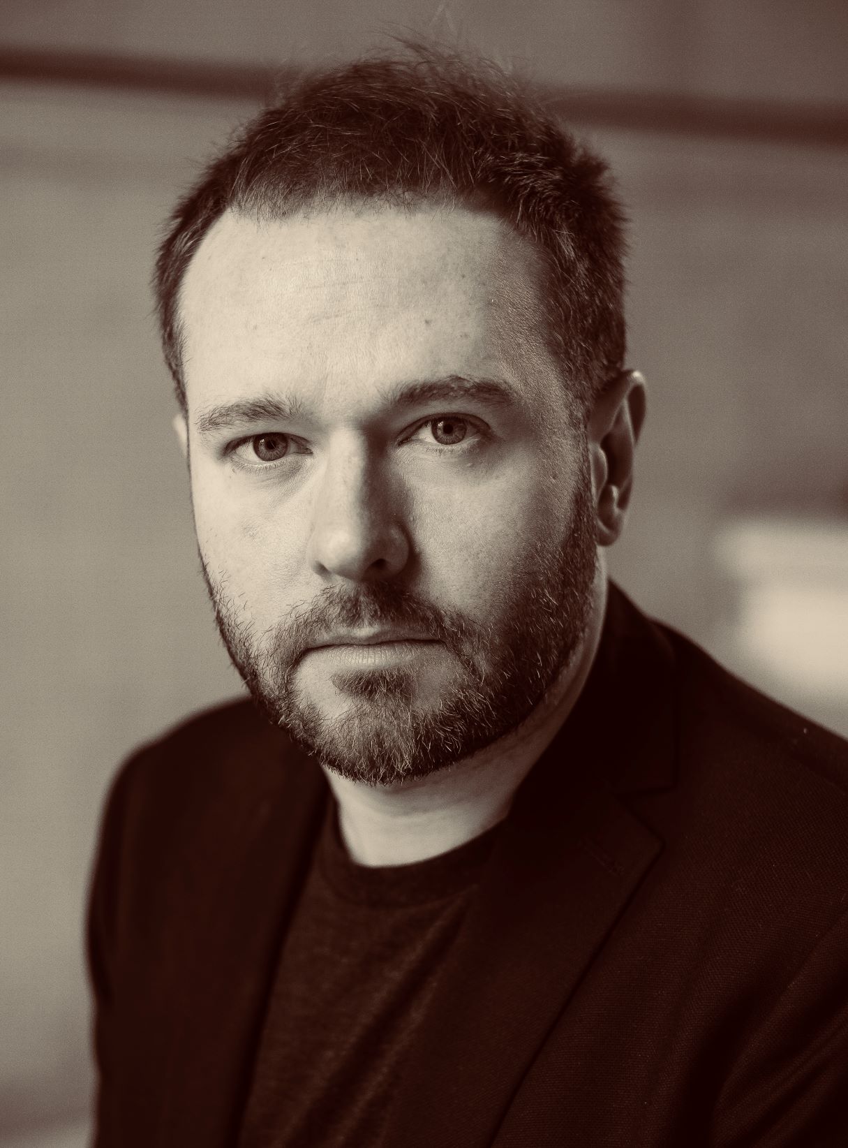 Greyscale headshot of Paul Stephens, a man with a suit jacket