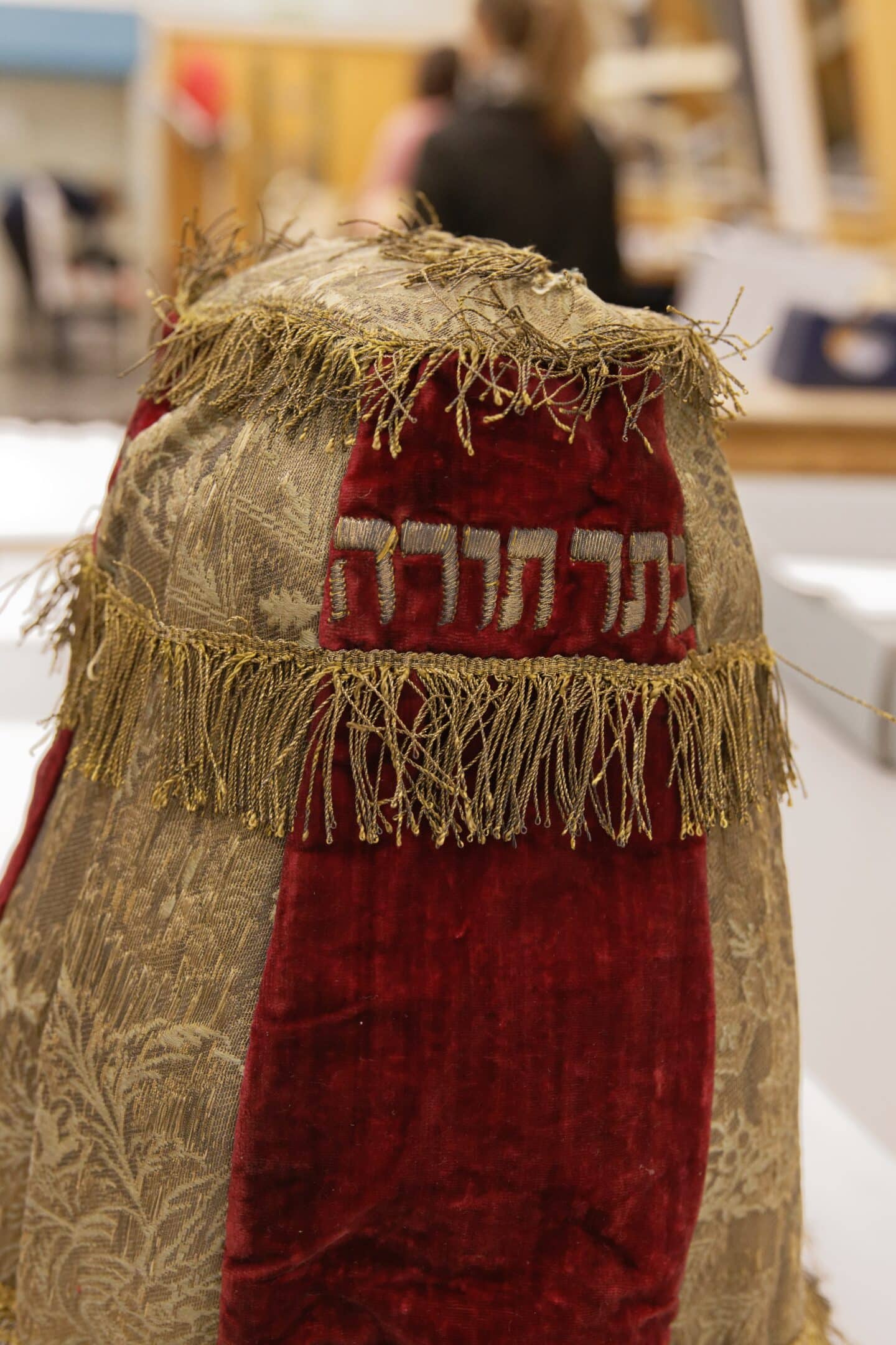 Red and gold mantle with a Hebrew inscription at the top