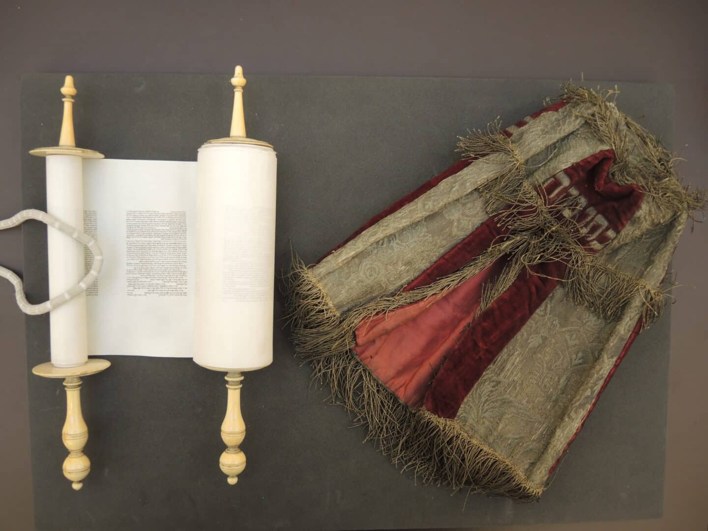 The mantle and scroll are pictured, housed in a box with a white tissue paper lining.