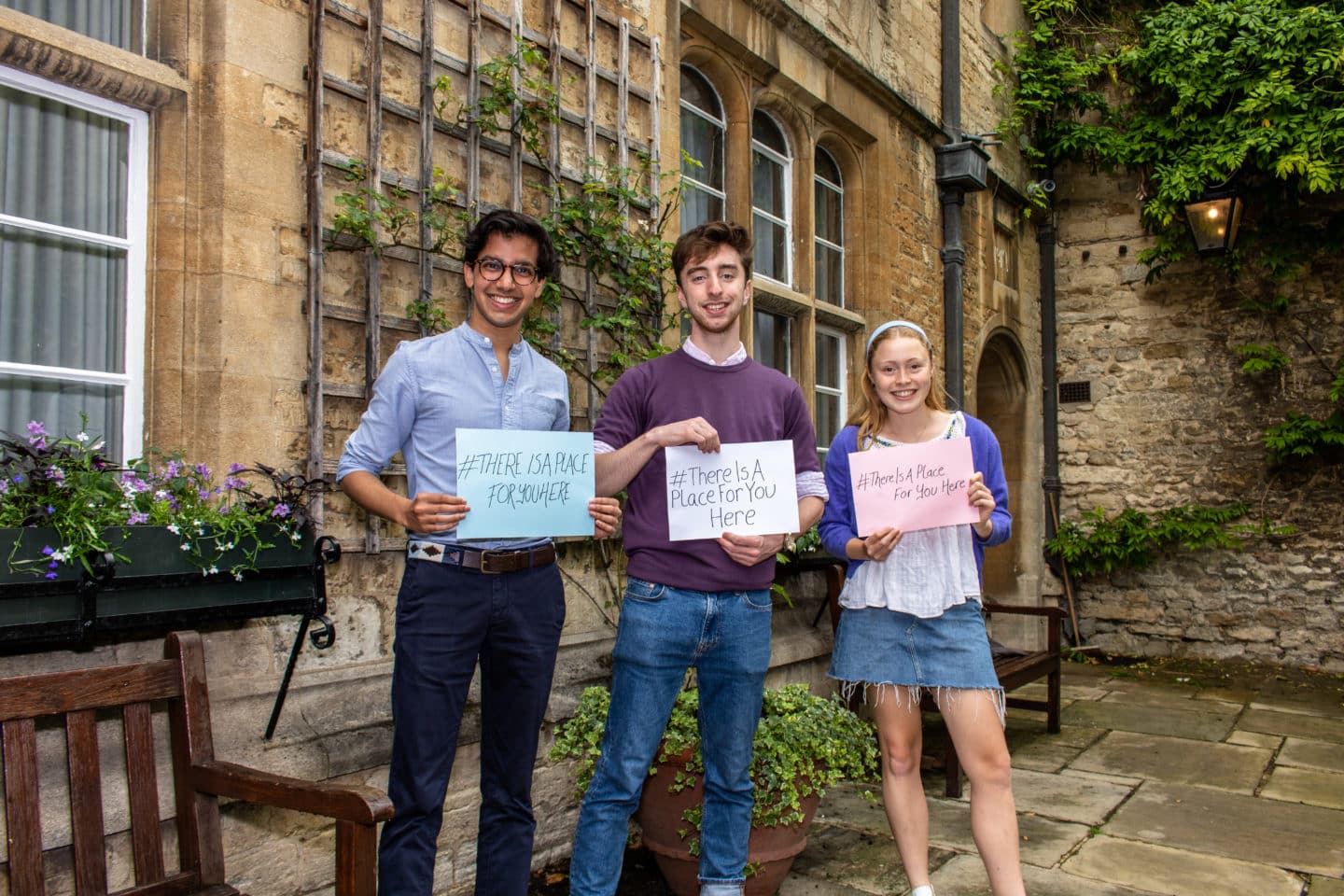 Current students hold signs reading hashtag there is a place for you here