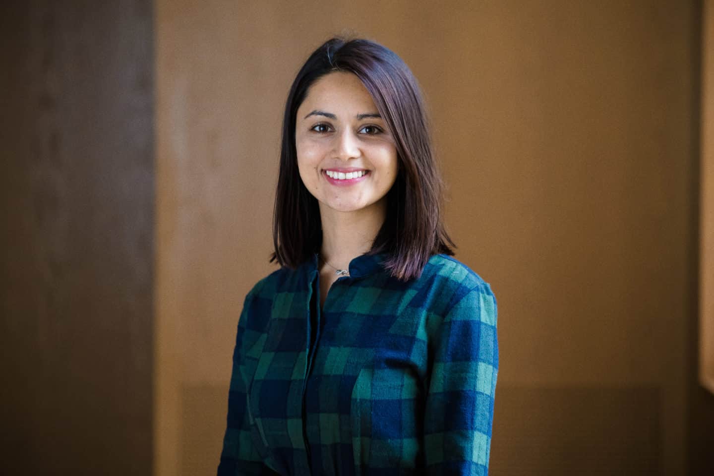 Headshot of Srijana Regmi, a young woman in a checked blue shirt