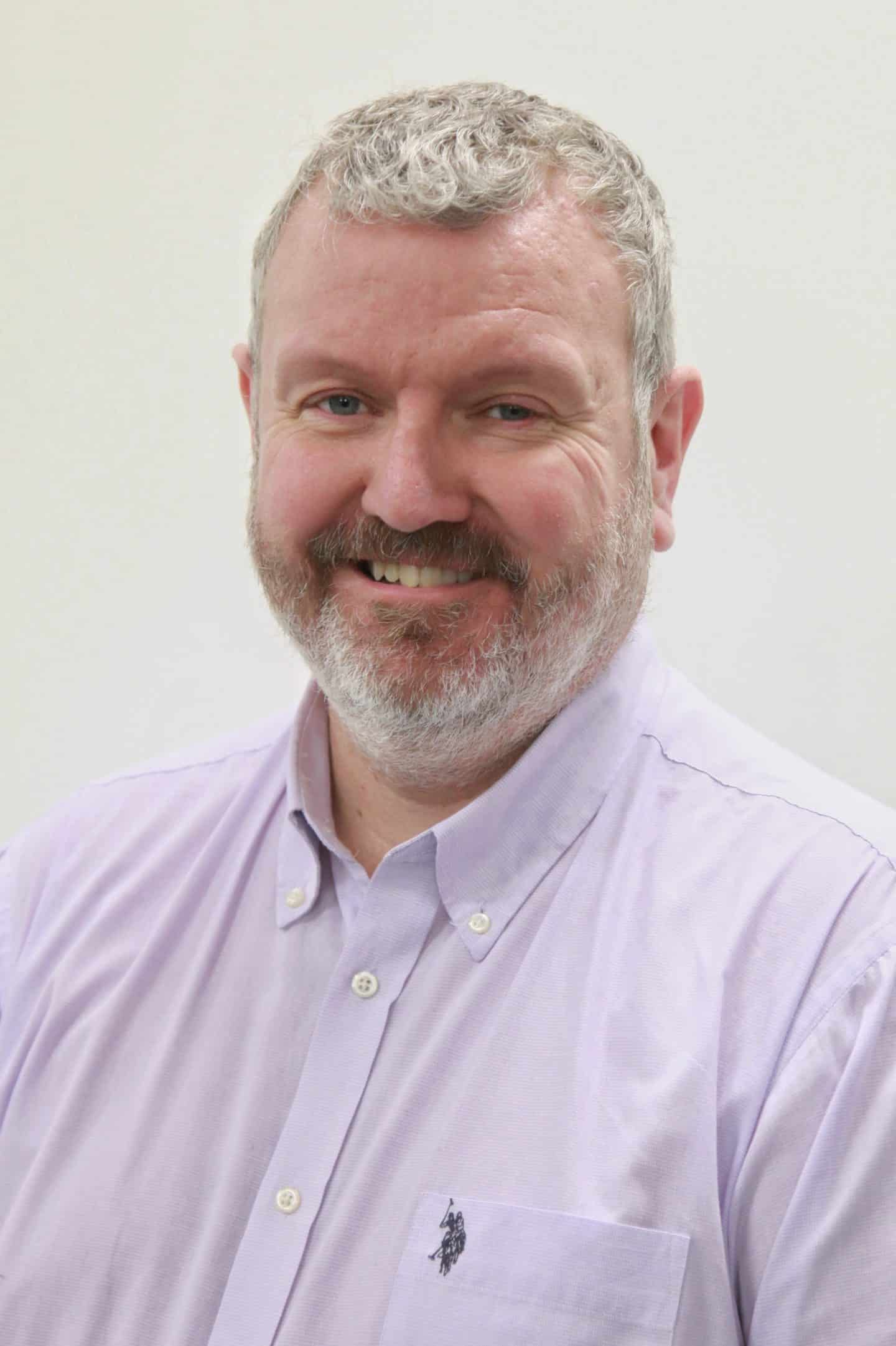 Headshot of Steve Miley, a man in a pink shirt