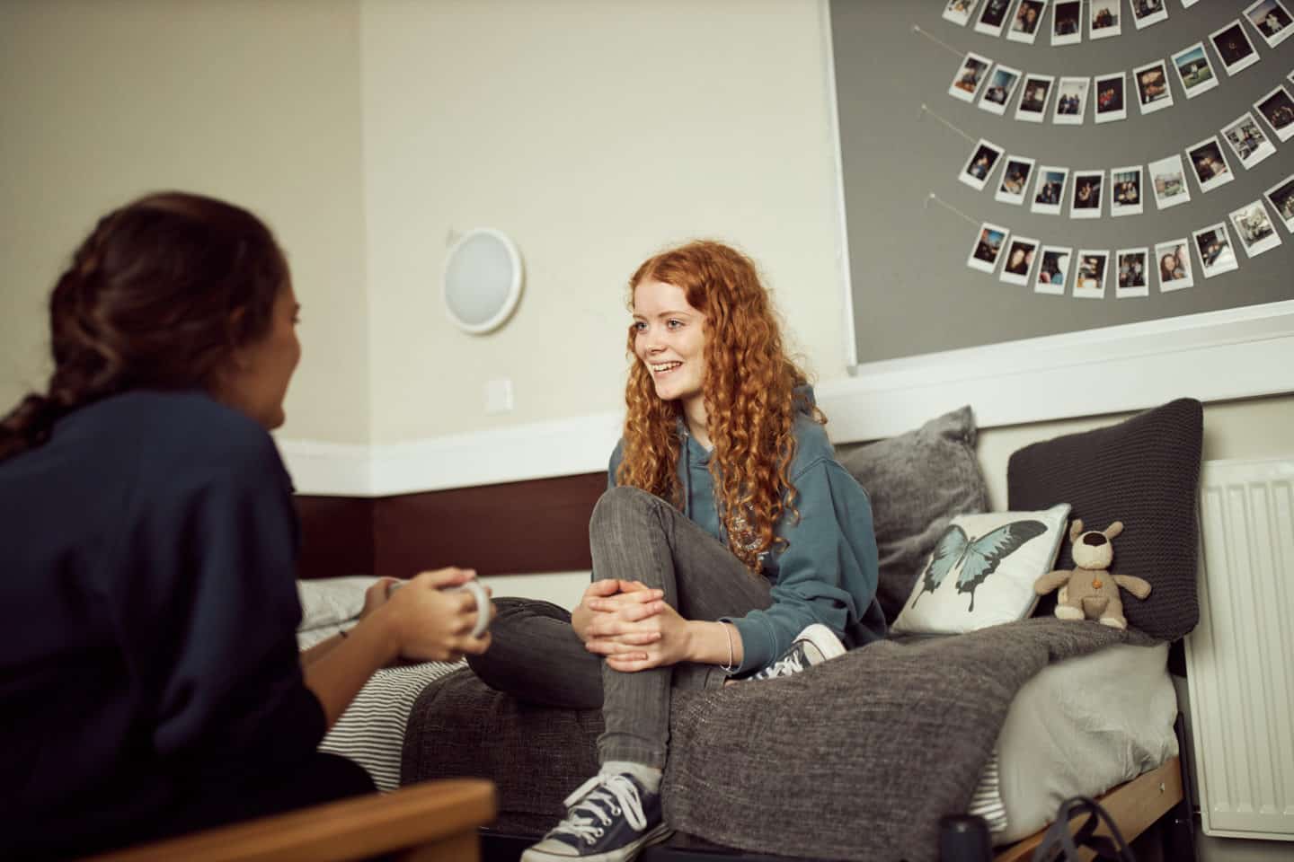 Two students sitting and talking in a bedroom