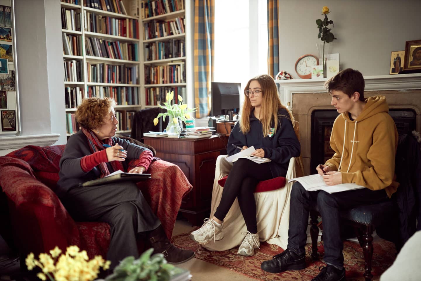 Students and their tutor sitting in an office with books