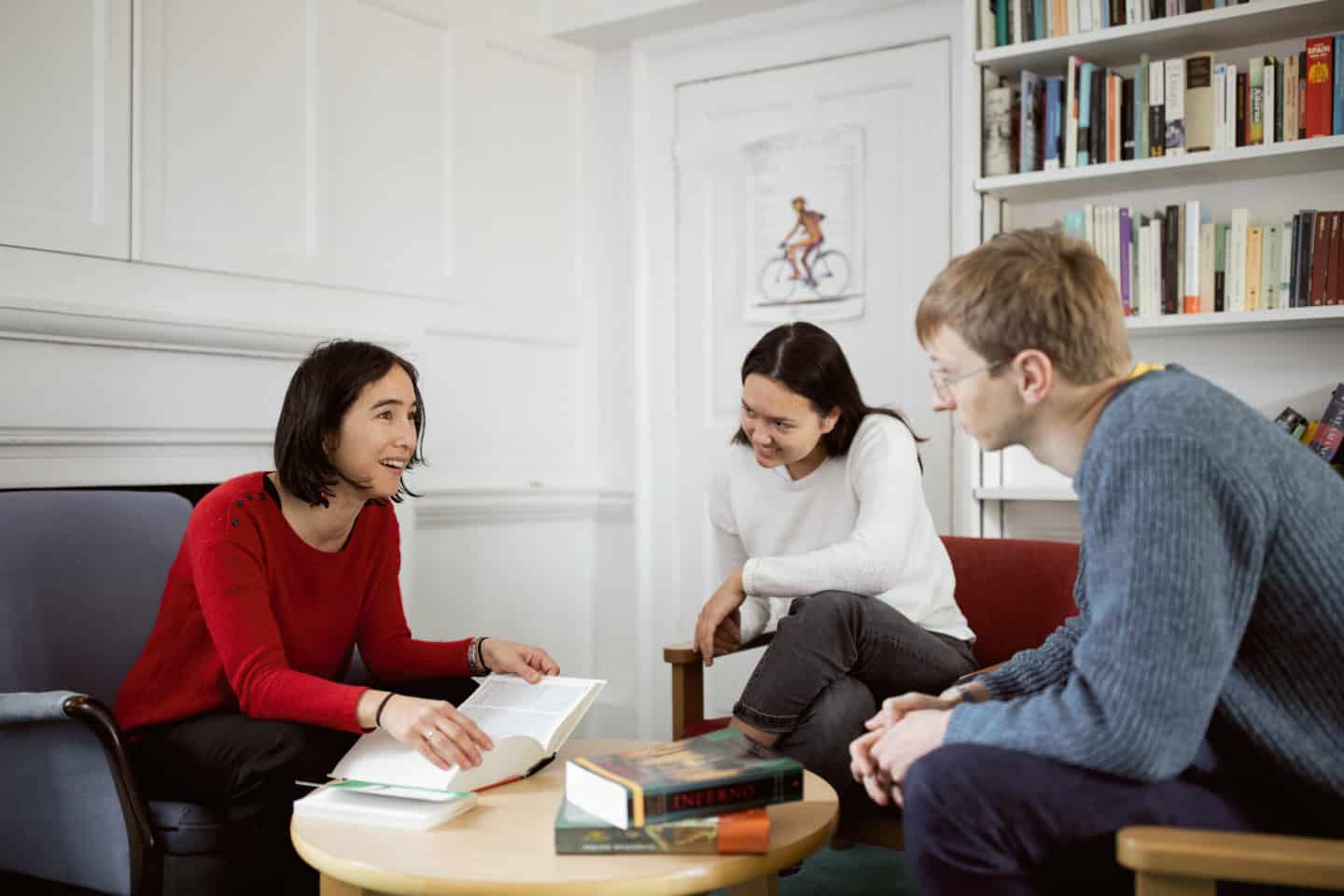 Students and their tutor sitting in an office with books