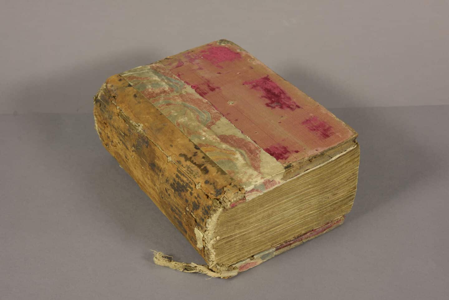 Thick old book of Greek Gospels lying closed